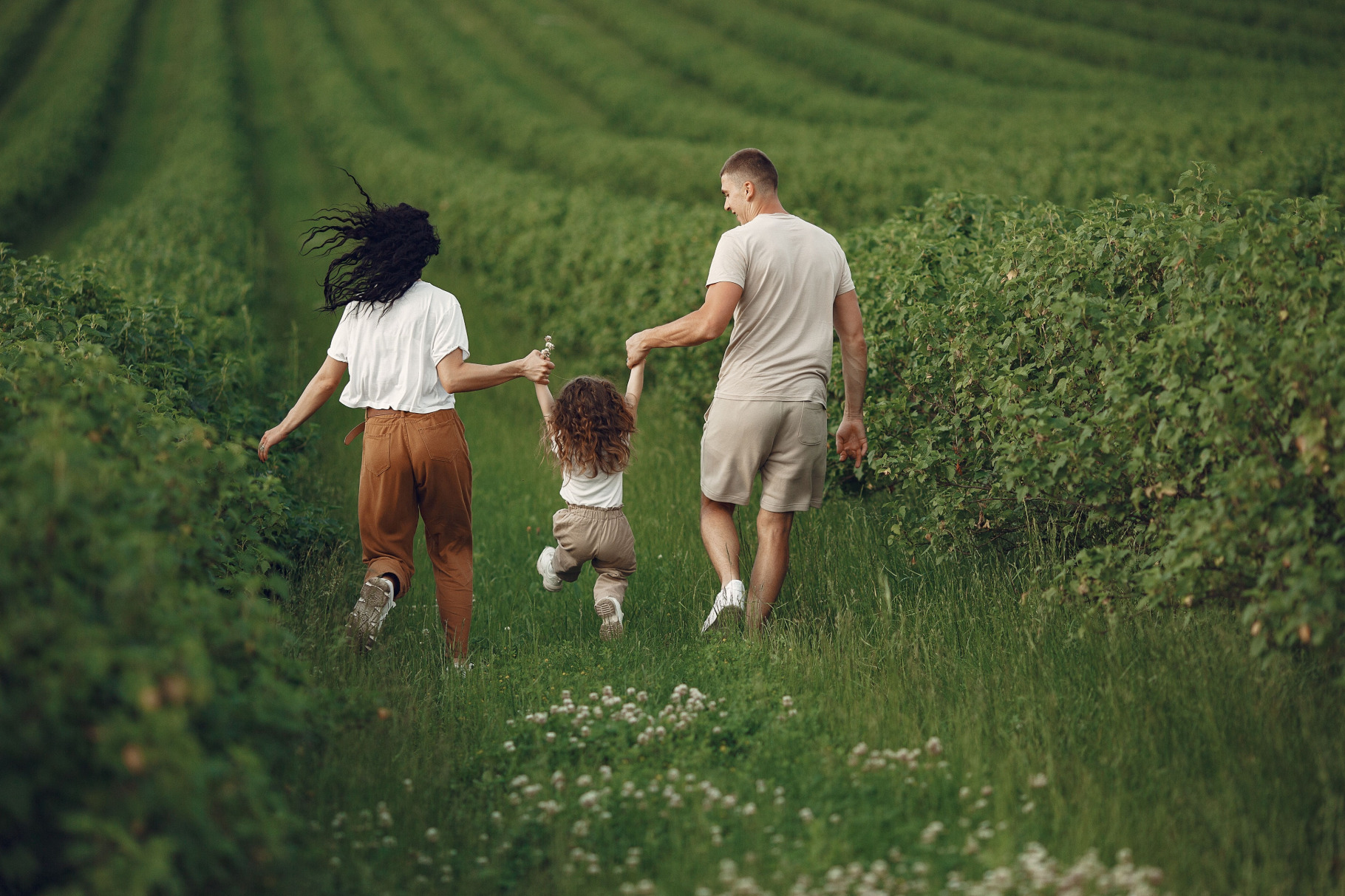 Couple avec un enfant, marchant dans les vignes, symbolisant l'harmonie familiale et la thérapie avec Valerie Siino